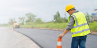 Safety-conscious construction worker walking on a road